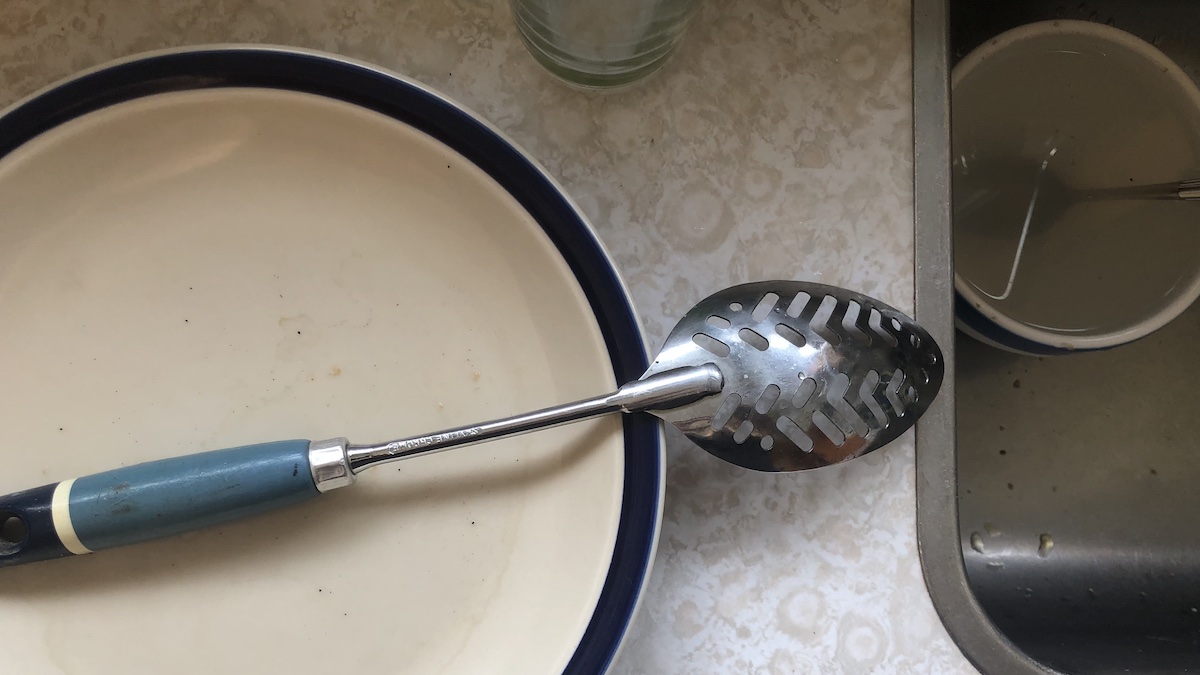 A photo of a kitchen sink at the author's family bach. The dishes have been abandoned.