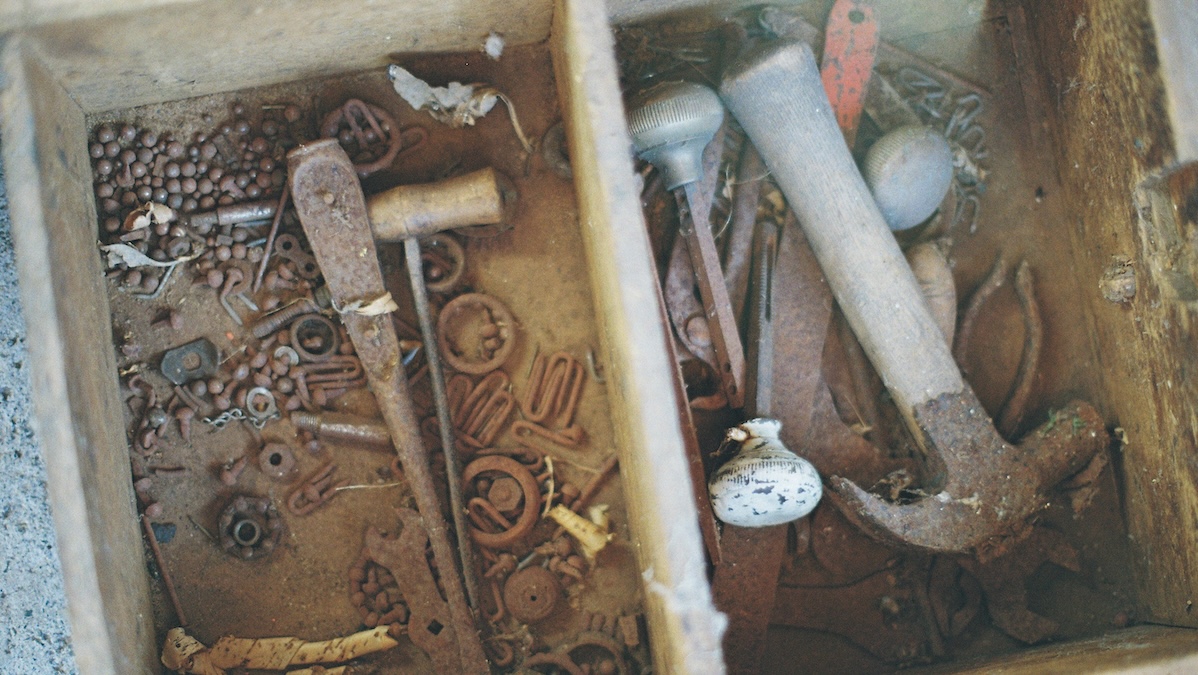 A dusty and rusty collection of old hand tools on a workbench
